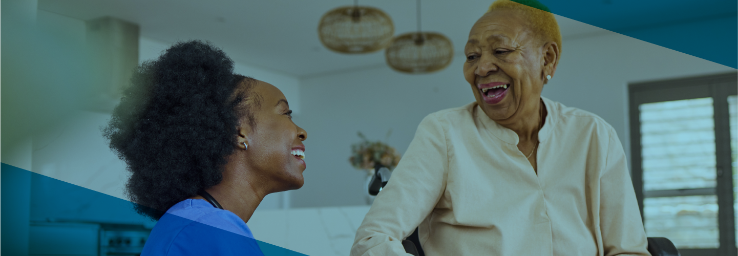 A smiling caregiver shares a joyful moment with an elderly woman at home, highlighting the companionship and support provided by personal care services.