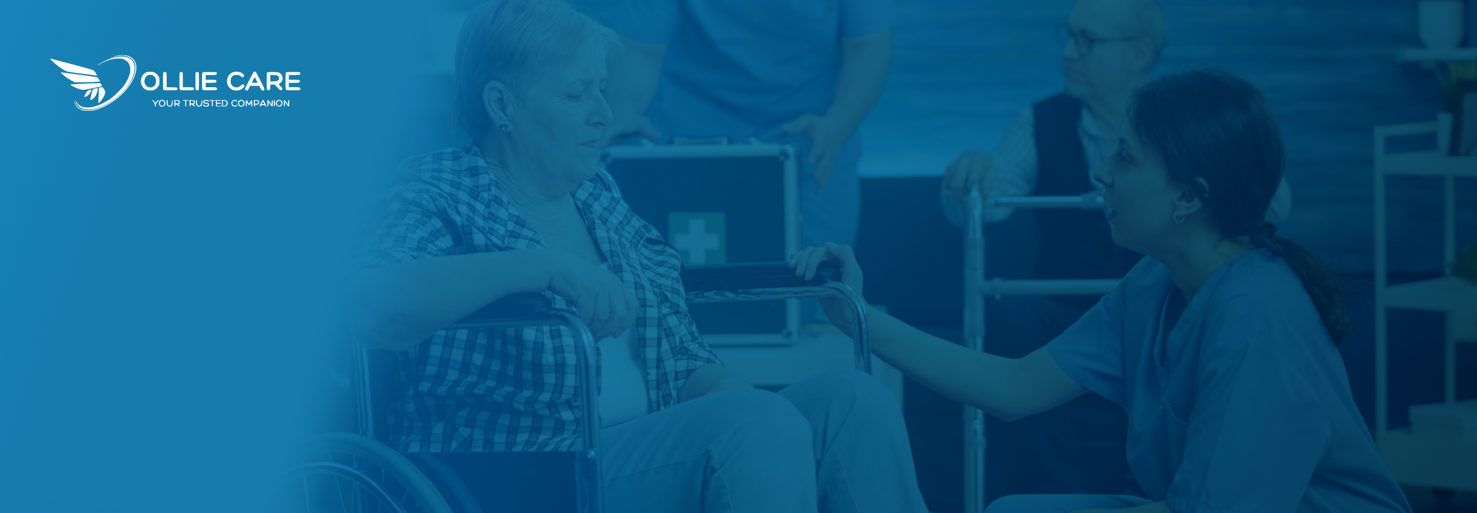 A compassionate caregiver in a blue uniform kneeling beside an elderly woman in a wheelchair, engaging her with a reassuring gesture in a professional care setting.